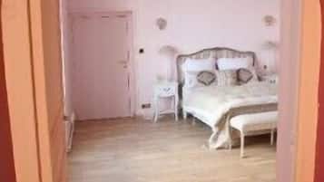 A bedroom with a bed, bedside tables, and a door.