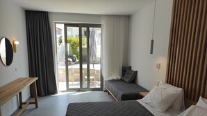 A bedroom with a bed, a bedside table, a bench, and a view of the outside.