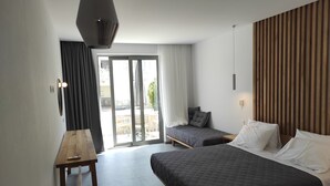 A modern hotel room with a large bed, a smaller bed, a desk, and a sliding glass door leading to an outdoor area.