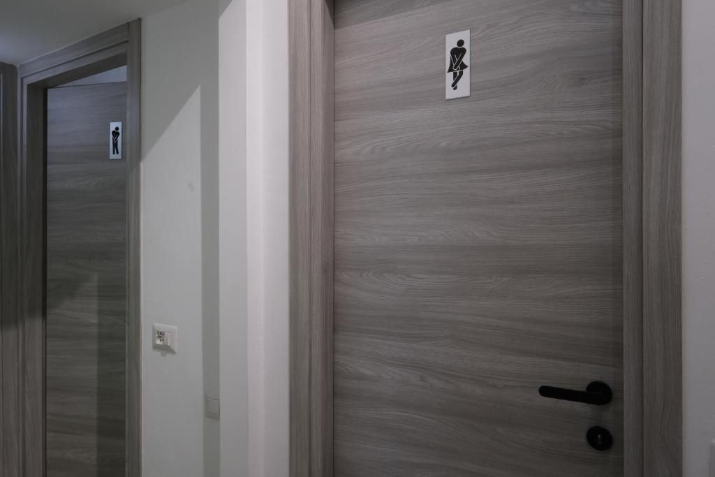 Un pasillo con puertas, una de ellas con el letrero de un baño.
