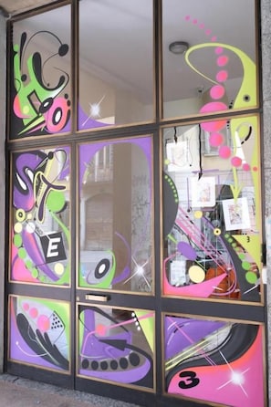 A glass door with colorful abstract designs and a visible number '3' on the lower right. - Hostel 3 (Milan)