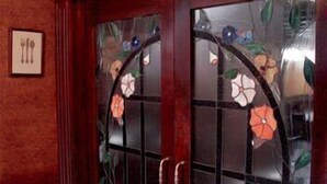 A door with a glass panel and a floral design. - Hotel Príncipe (Tulua)
