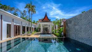 Un resort moderno con una piscina cristalina, un edificio tradicional con techo rojo y una pared de azulejos.
