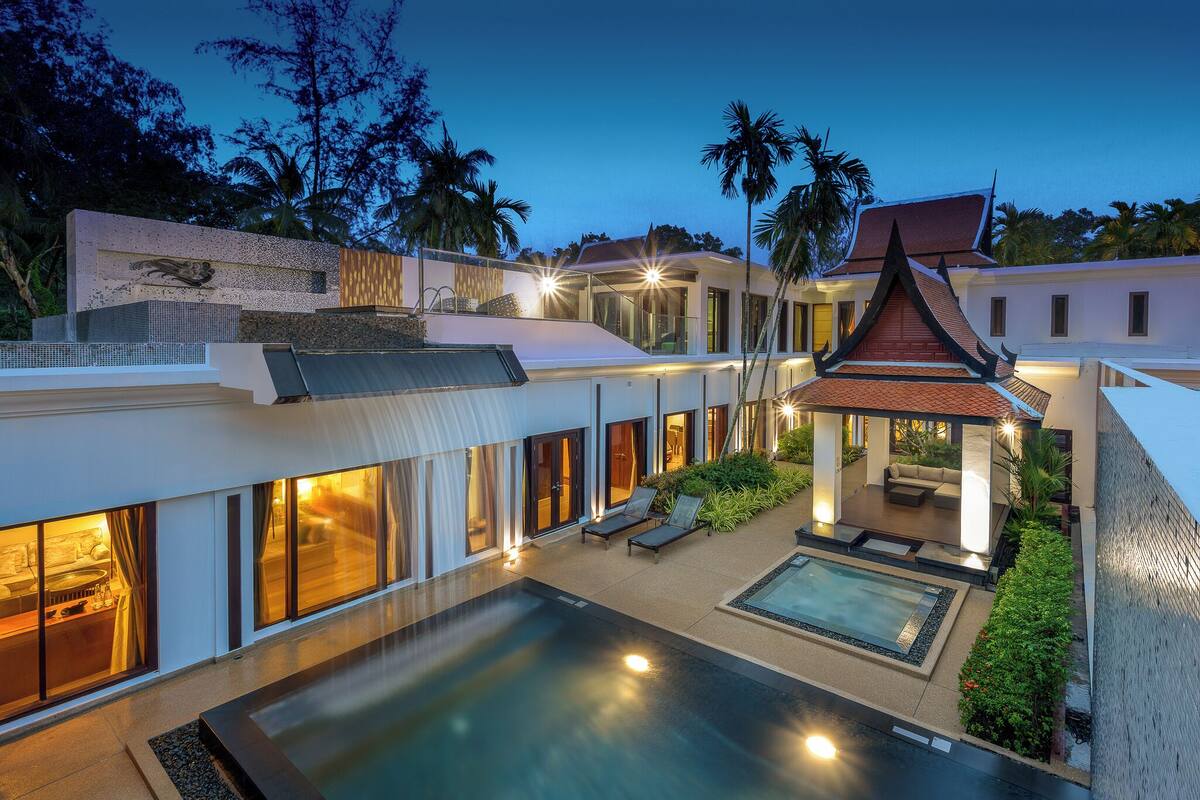A modern resort with a swimming pool, outdoor seating, and a waterfall feature.