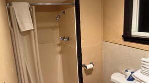 A bathroom with a shower, toilet, and towel rack.