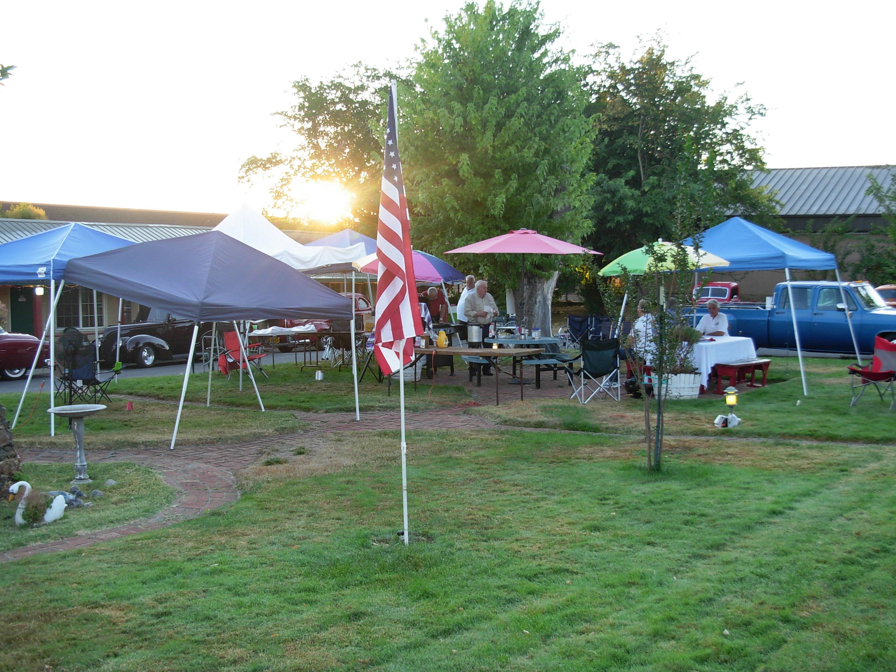 An outdoor event with tents, tables, and a flag.