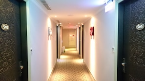 Guest rooms are accessible from this well-lit corridor with numbered doors.