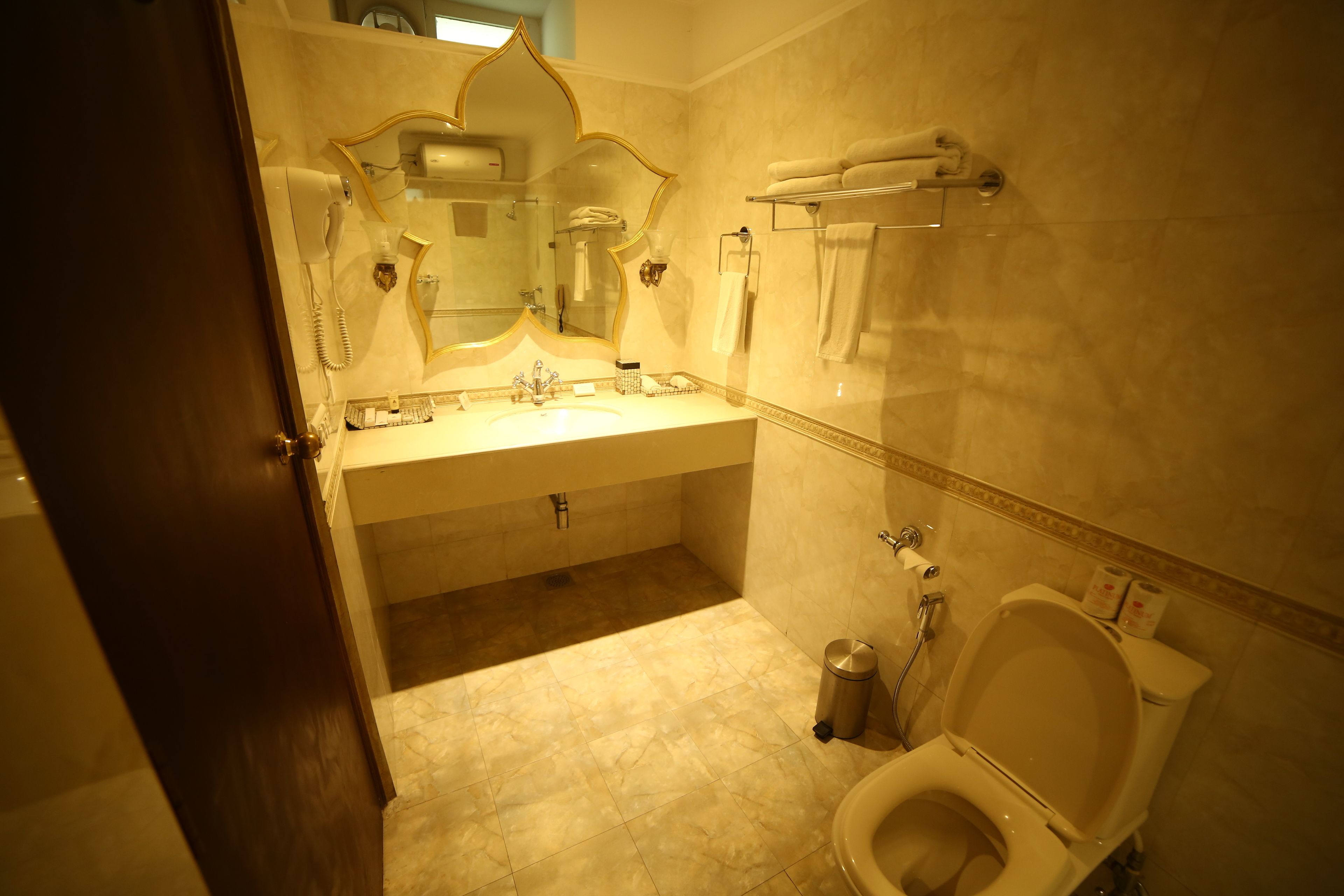 A bathroom with a sink, mirror, towel rack, and toilet.