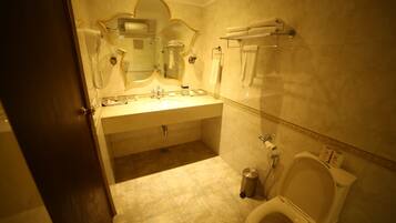 A bathroom with a sink, mirror, towel rack, and toilet.