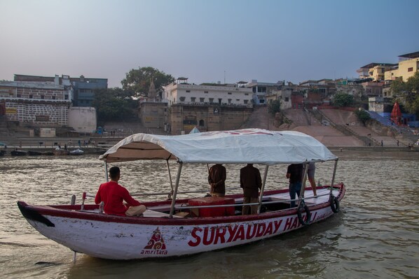 Un bote con una cubierta que dice "Suryauday Han" en un río.