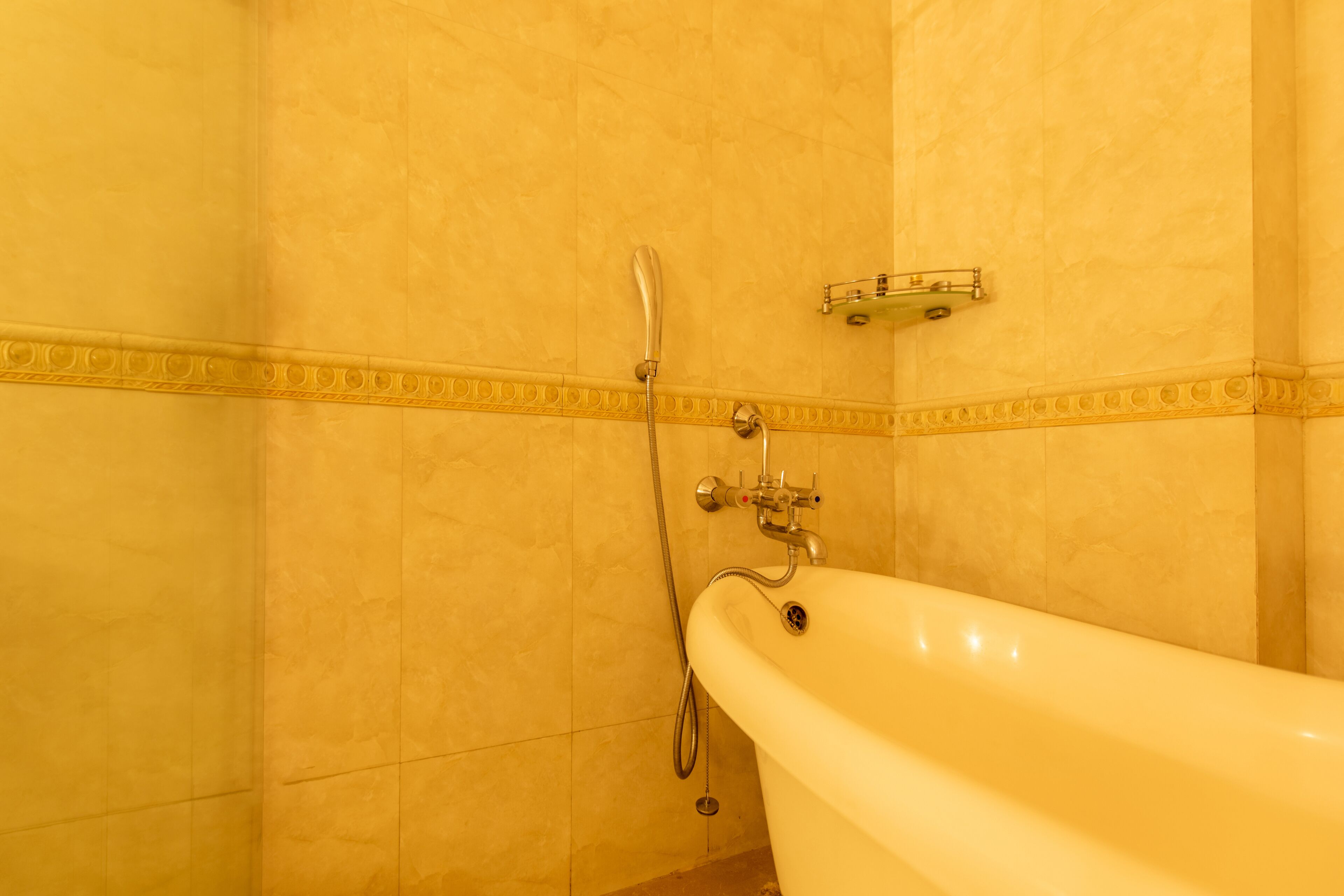 Un baño con bañera, ducha y un perchero para toallas.