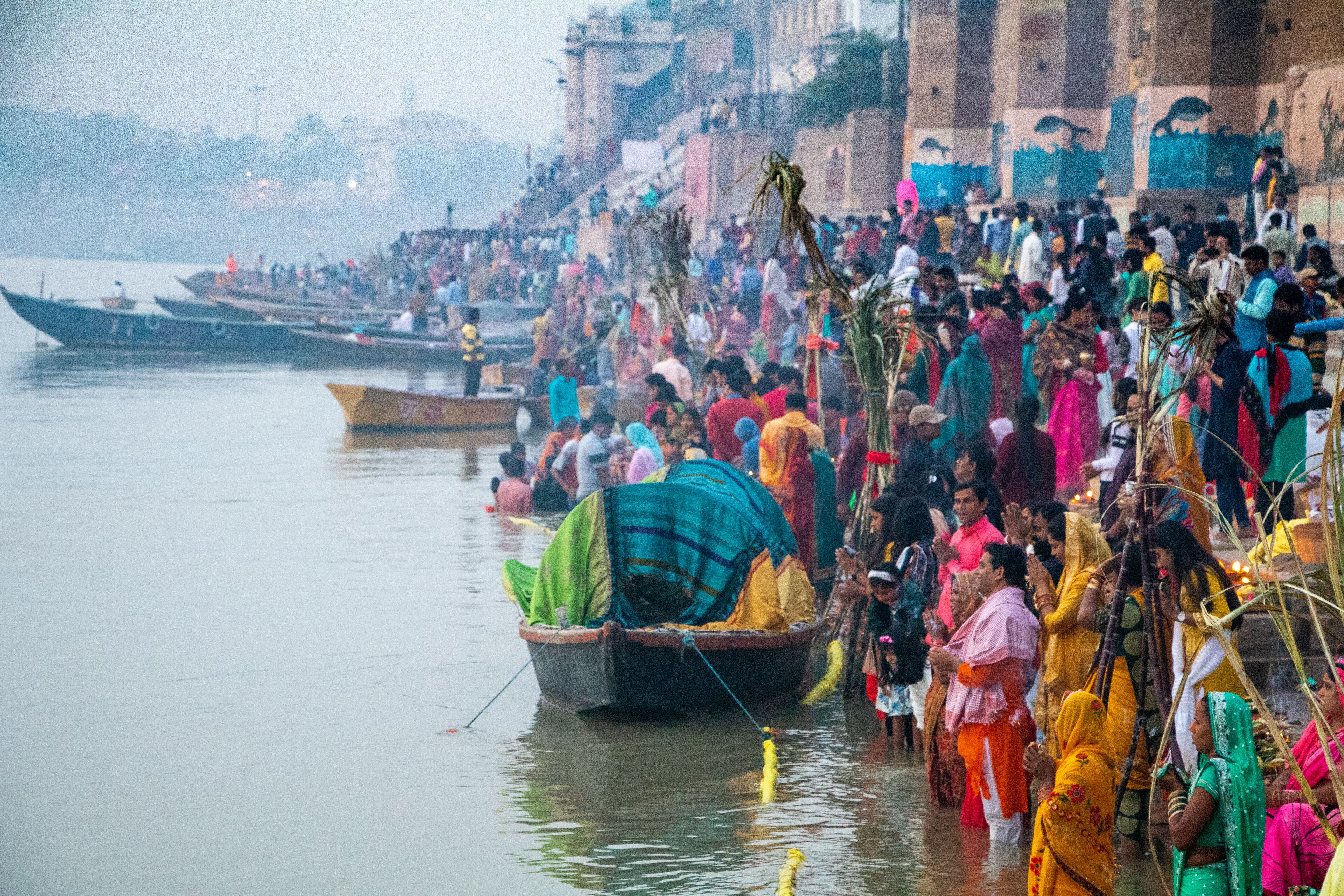 Une rive animée, bondée de monde et de bateaux.