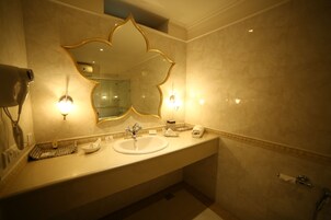 Un baño con un espejo grande, dos lavamanos y un perchero para toallas.