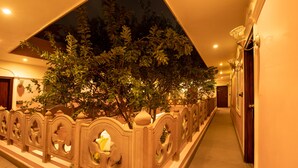 A corridor with a decorative railing and a tree. - Amritara Suryauday Haveli (Varanasi)