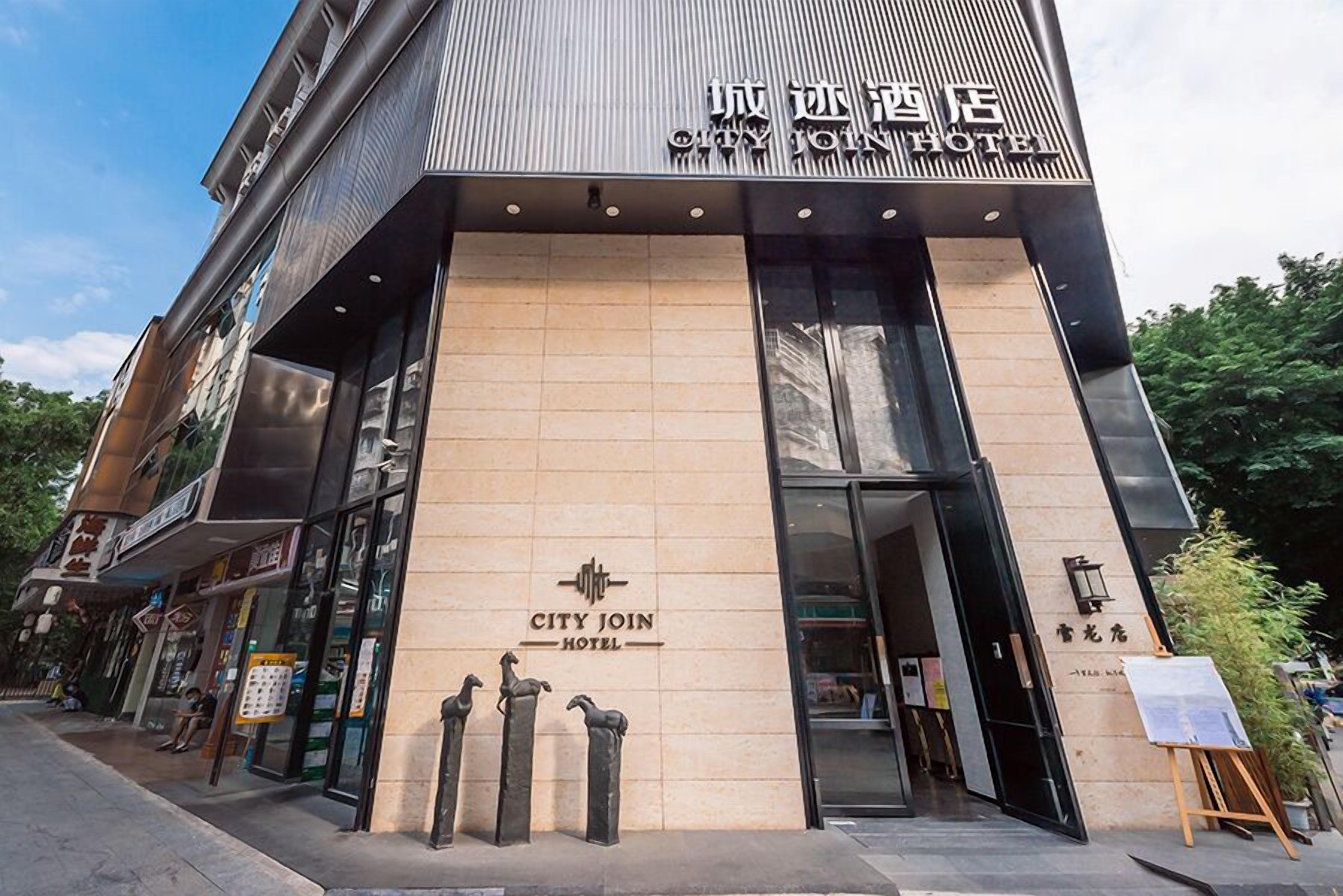 Un hôtel moderne, reconnaissable à son enseigne bien visible où l’on peut lire « CITY JOIN HOTEL ».