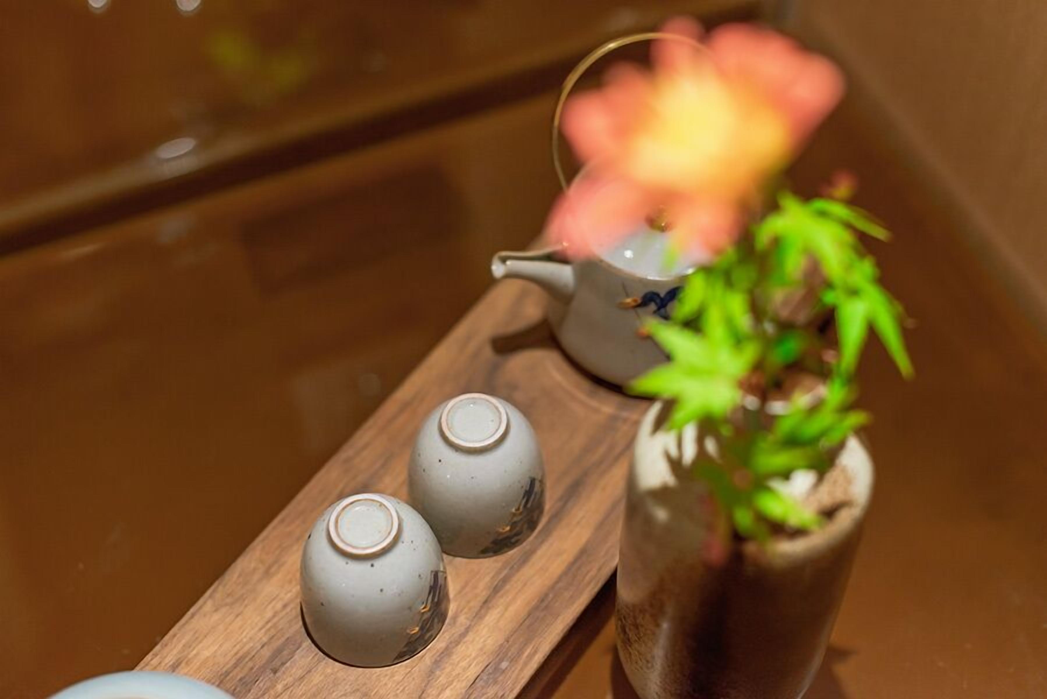 Un plateau en bois avec deux théières et une plante en pot.