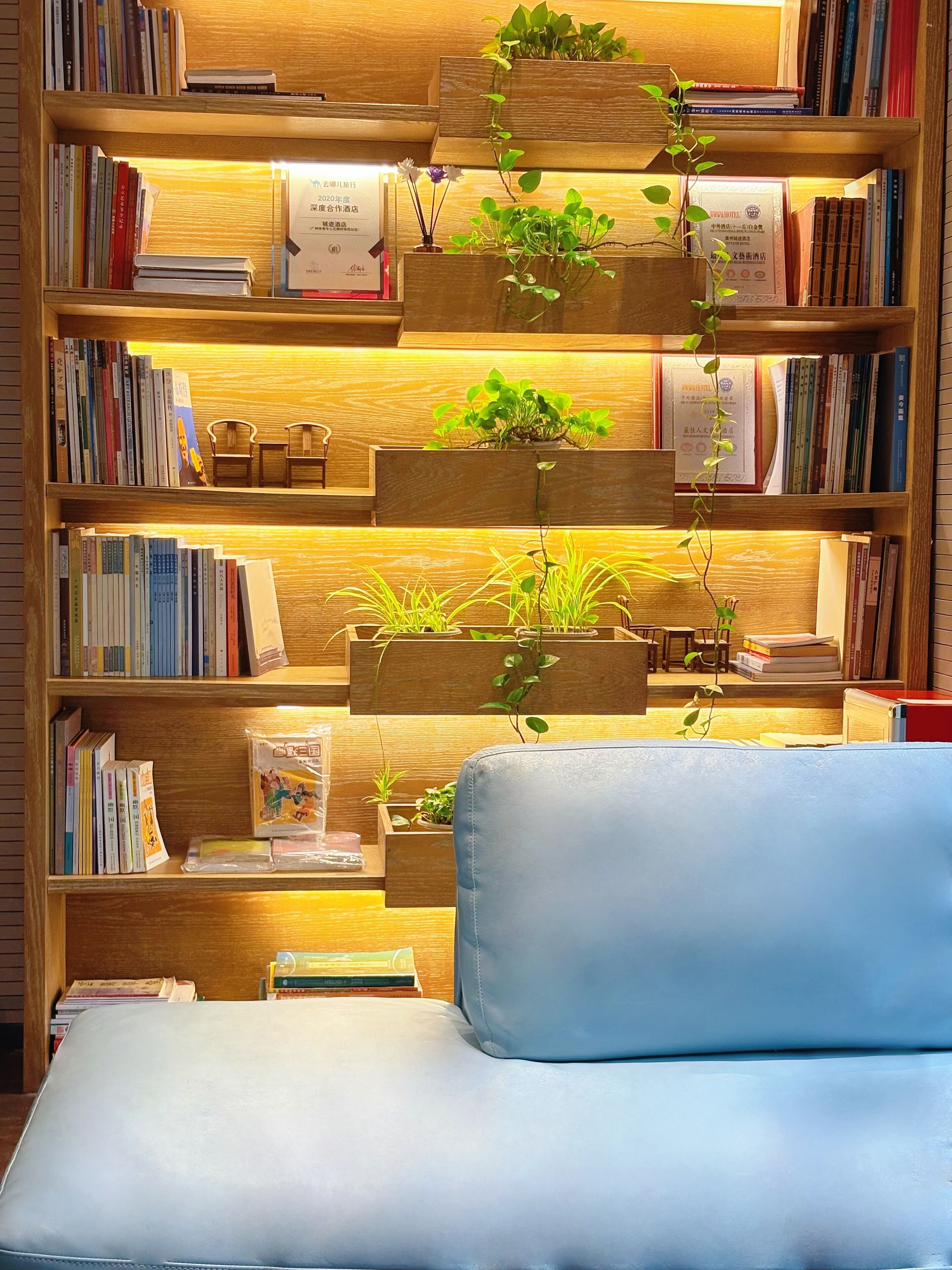A bookshelf with multiple shelves filled with books and potted plants.