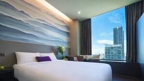 A modern hotel room with a large bed, a view of a cityscape, and a textured wall. - V Hotel Lavender (Singapore)