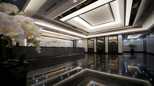 A modern hotel lobby with a reflective floor, a reception desk, and a large artwork on the wall. - V Hotel Lavender (Singapore)
