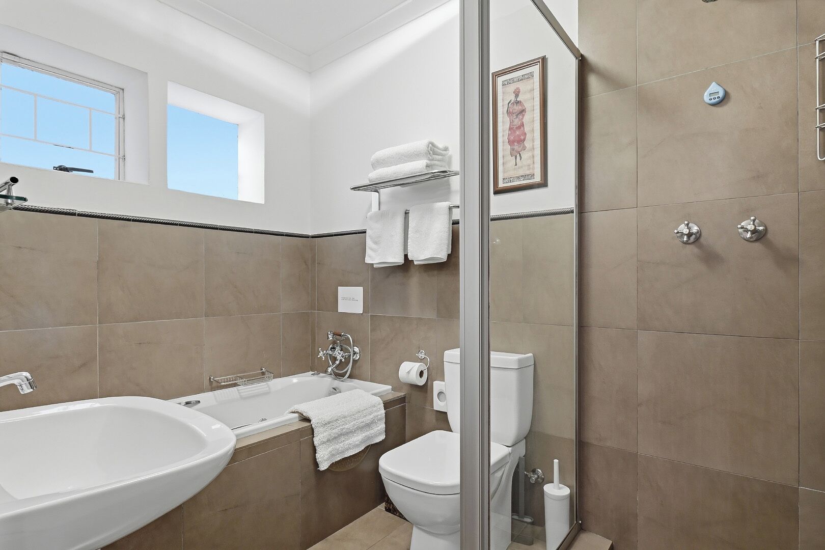 Une salle de bain moderne équipée d’une baignoire, de toilettes et d’un espace douche.