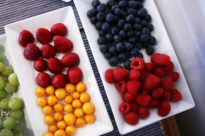 Three white rectangular plates with different fruits. - Paradiso Guest House (Cape Town)