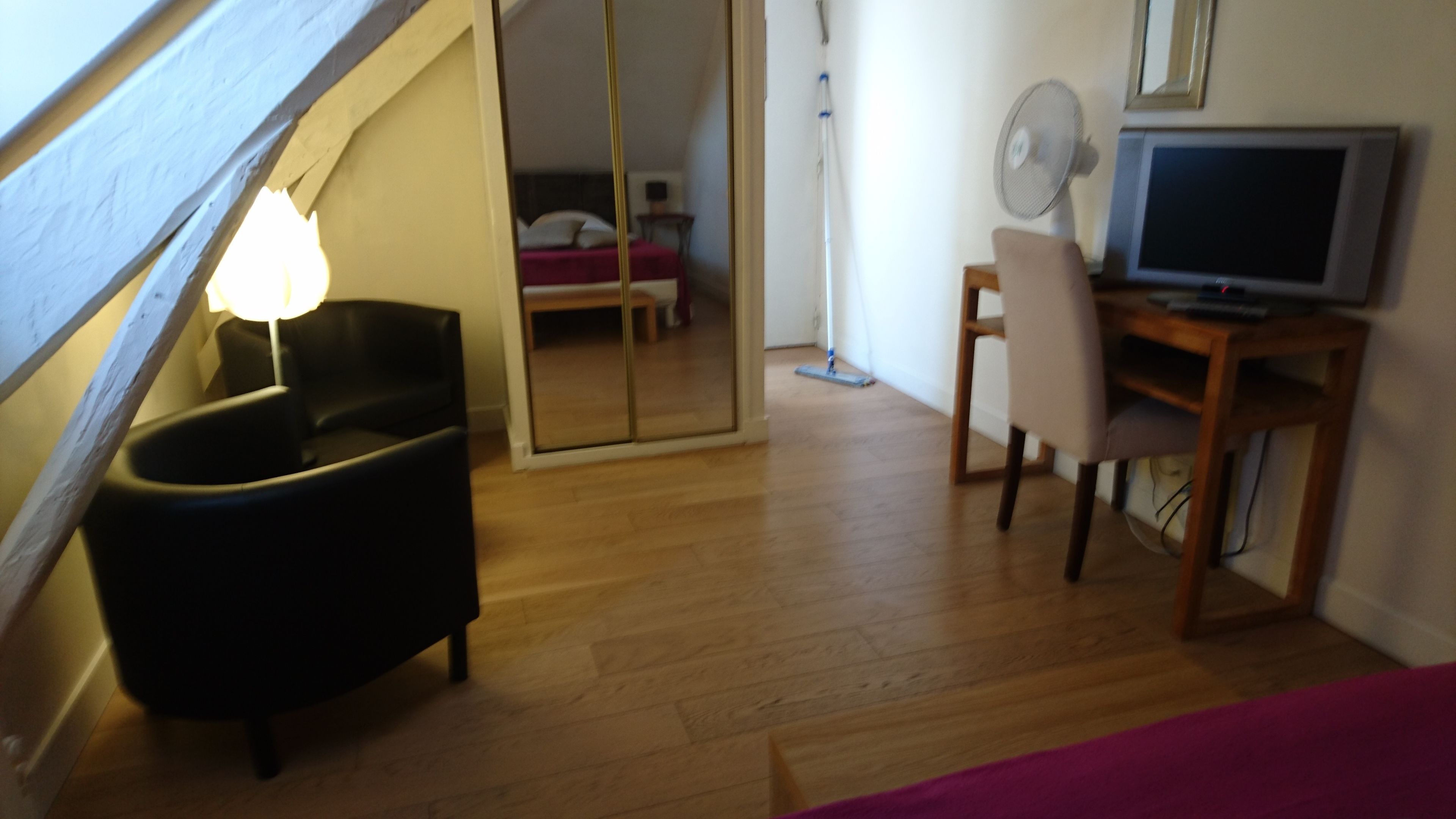 Une pièce comprenant un lit, un bureau avec un ordinateur, une chaise, une lampe et un téléviseur.