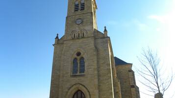 En kirke med et højt tårn, buede vinduer og et ur.