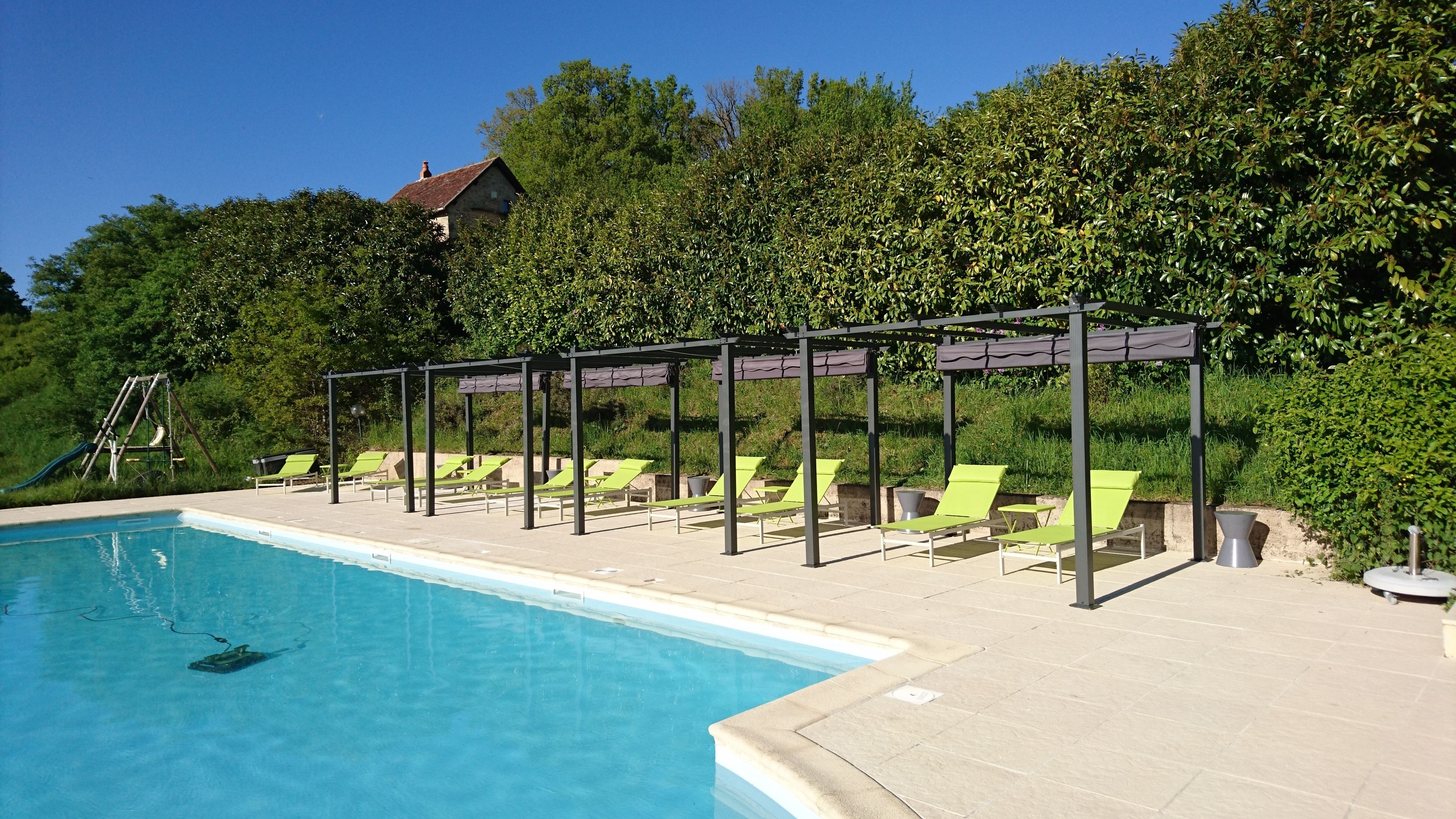 Ein Pool mit Liegestühlen und einer Pergola.