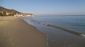 A beach with a clear sky, calm sea, and buildings along the shore. - Hotel Ariston (Varazze)