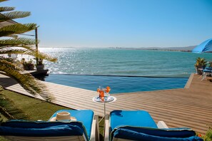 Piscine extérieure, parasols de plage, chaises longues