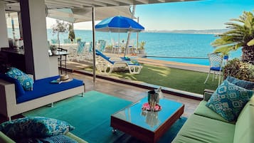 Alberca al aire libre, sombrillas en la alberca y camastros