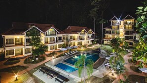 A hotel with multiple buildings, a swimming pool, and outdoor seating areas. - Anjungan Beach Resort (Pangkor Island)