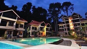A resort with multiple-story buildings, a swimming pool, and a night-time setting. - Anjungan Beach Resort (Pangkor Island)