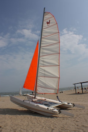 Sailboat Felix is docked on a sandy beach, offering a tranquil beach experience.