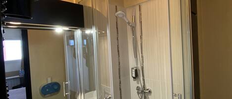 A modern bathroom with a glass-enclosed shower, a white sink, and a toilet.