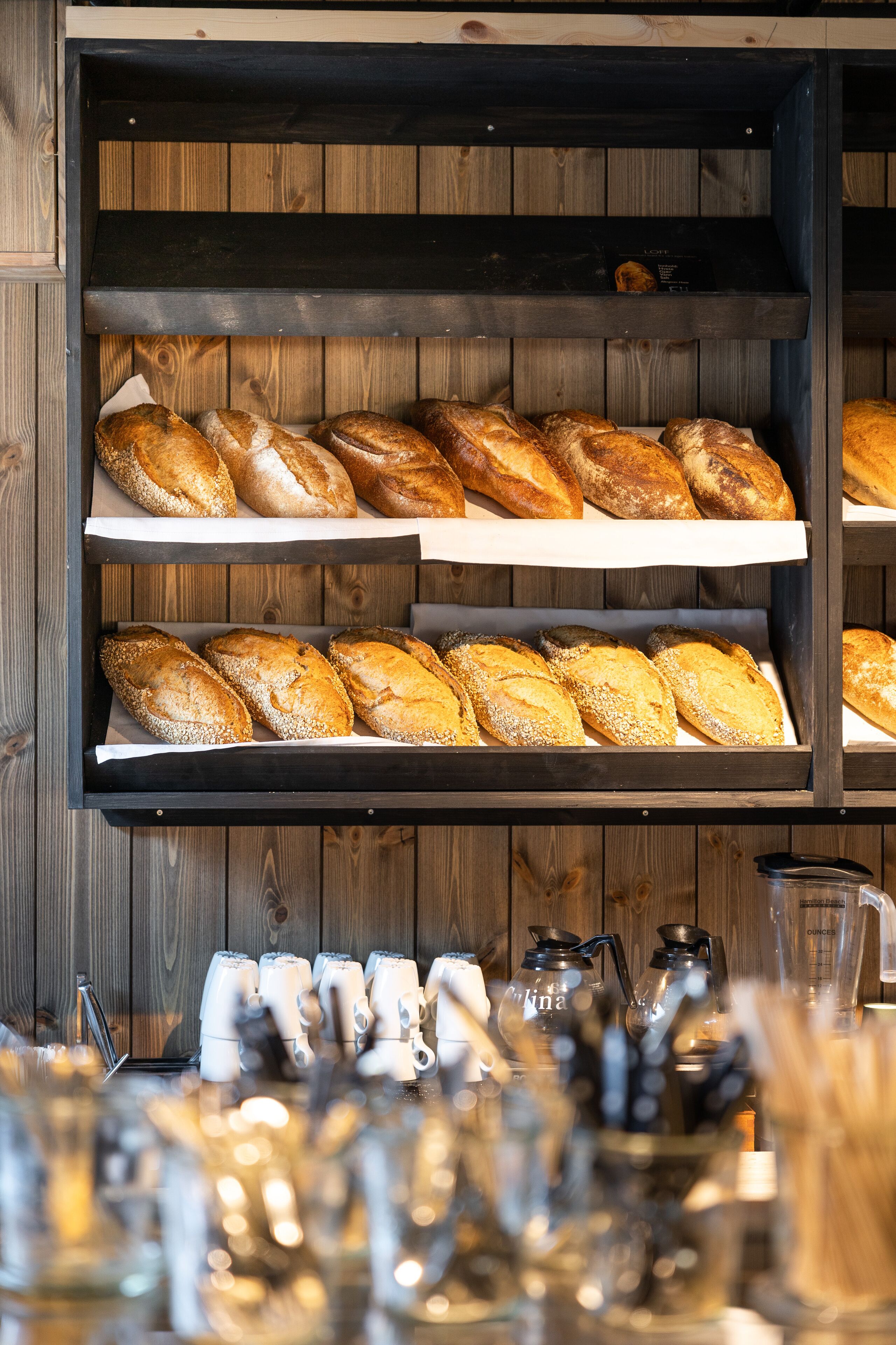 Mostrador de panadería con diferentes tipos de pan en estantes.