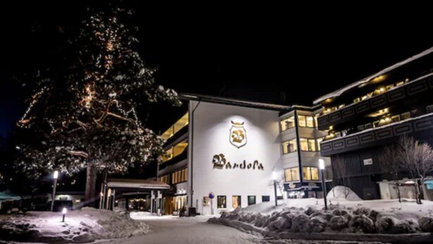 A hotel with a prominent logo on the facade, a covered entrance, and a snow-covered ground. - Bardøla Fjelltun (Hol)