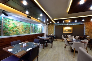 Enjoy dining in a stylish setting with a large aquarium and framed artwork.
