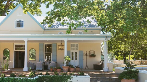 A house with a swimming pool, outdoor seating, and potted plants. - Auberge Clermont (Franschhoek)