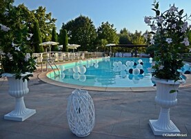 Una piscina al aire libre, sillones reclinables de piscina