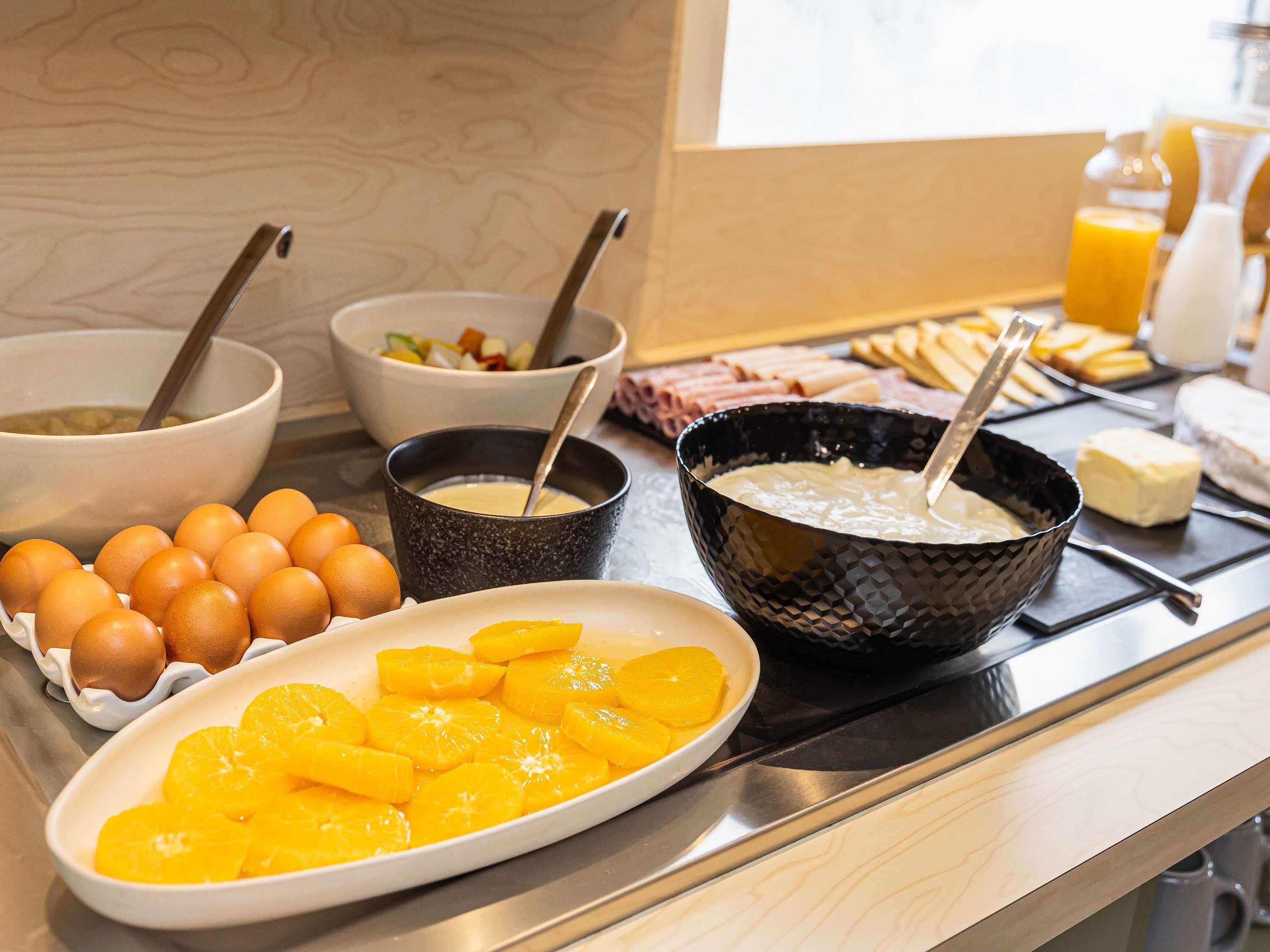 Un bufé de desayuno con diversos alimentos y utensilios.