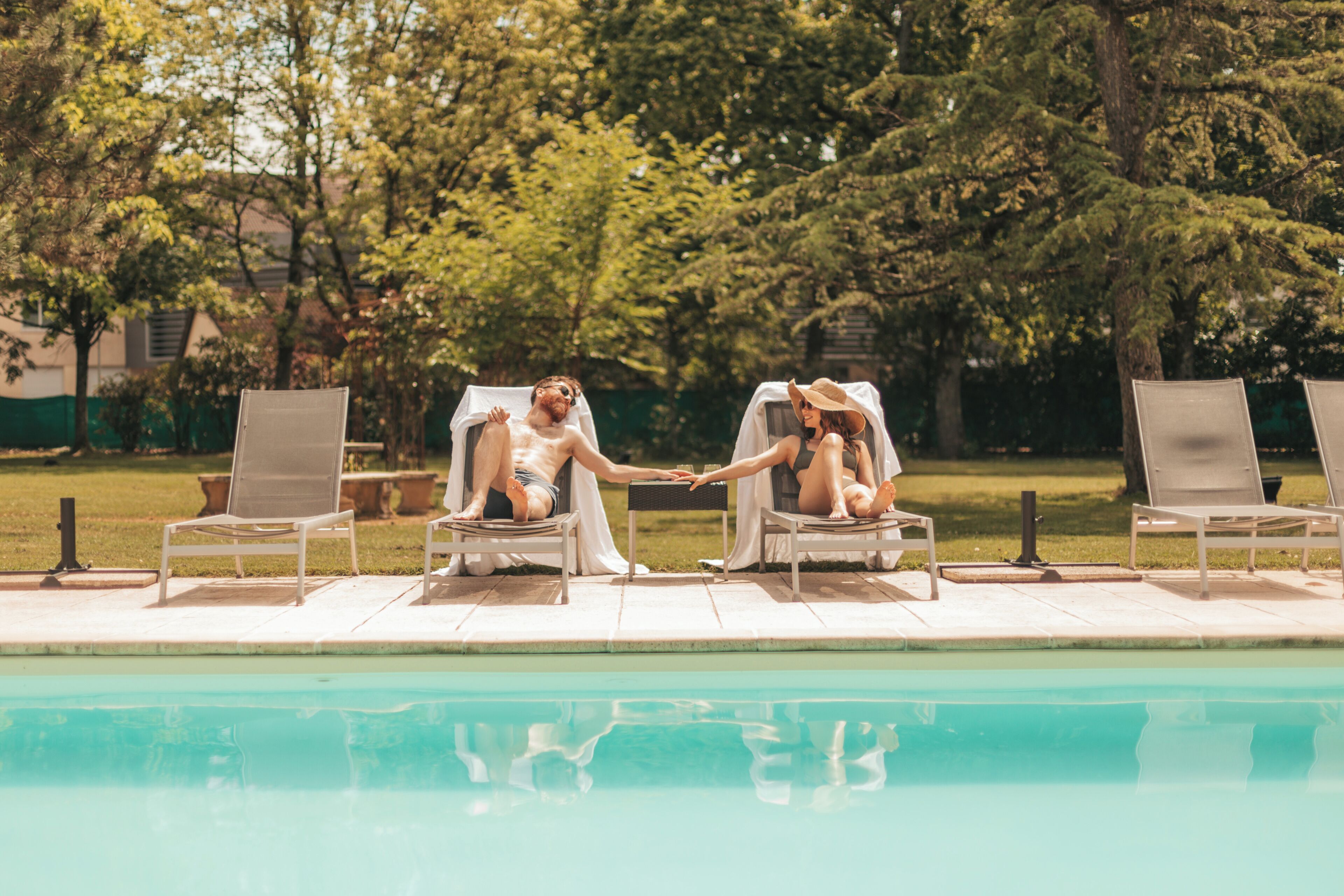 A poolside area with lounge chairs and a table.