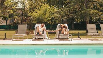 A poolside area with lounge chairs and a table.