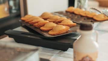 Un plateau de pâtisseries sur une table, avec une bouteille de sirop à côté.
