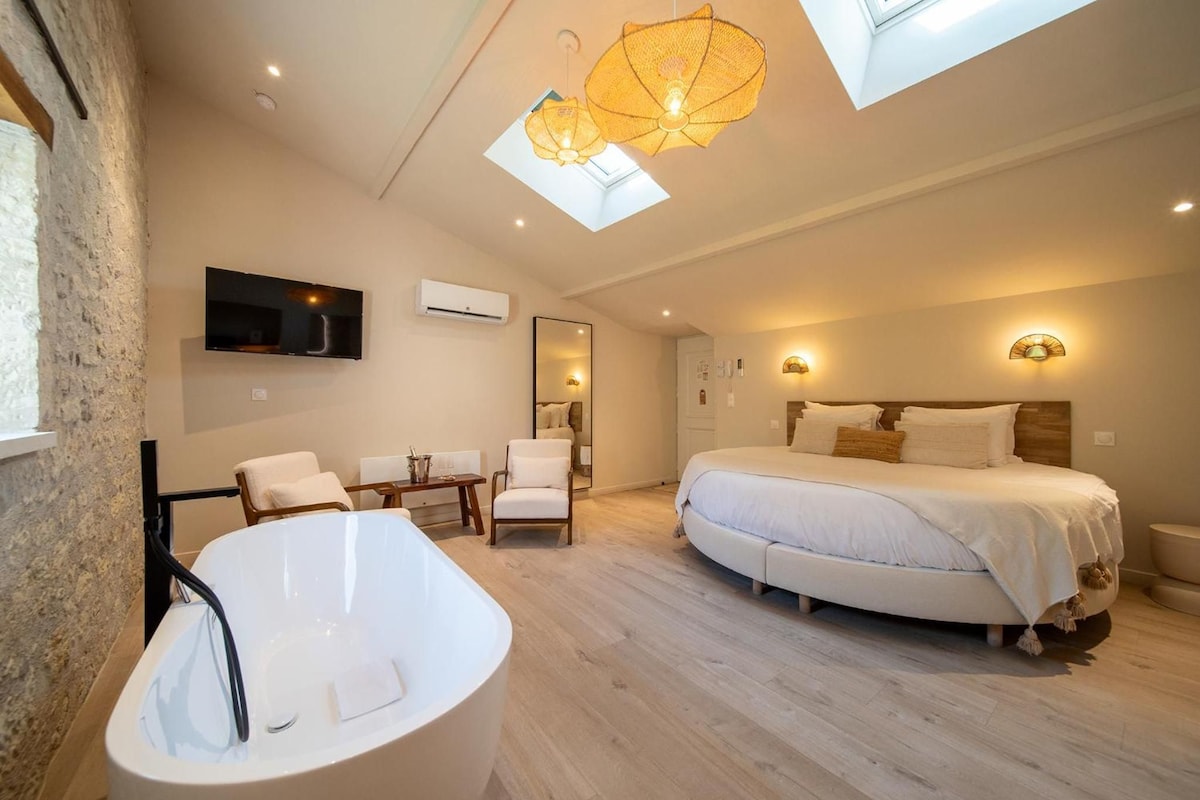 Un dormitorio moderno con una cama grande, una bañera y un tragaluz.