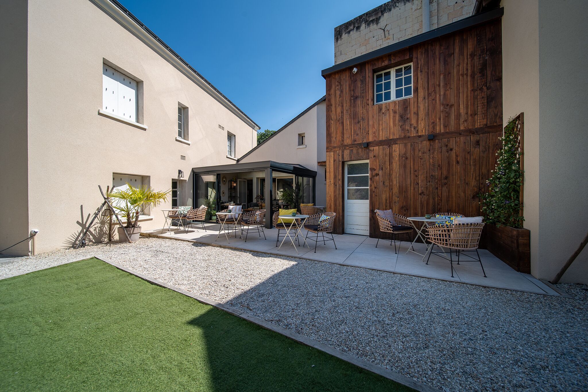 Un patio con zona de estar, un porche cubierto y un edificio de madera.