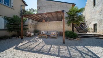 Un espace extérieur aménagé avec une pergola en bois, un canapé et une table, le tout abrité.