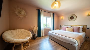 A bedroom with a large bed, a rocking chair, a window with curtains, and wall-mounted lights.