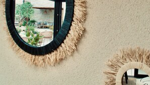 A circular mirror with a shaggy frame on a textured wall. - Hôtel Rive Sud (Chinon)