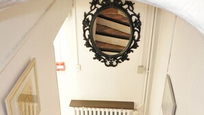 A wooden staircase with a white handrail and a radiator at the bottom. - Hôtel Select (Salon-de-Provence)
